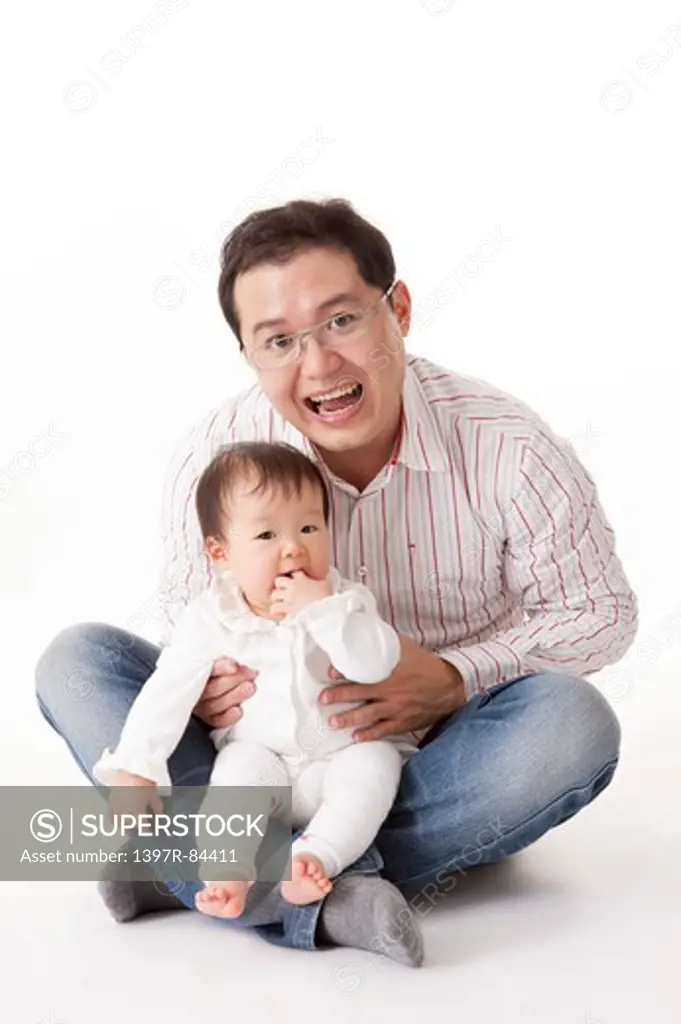 Father embracing baby girl and smiling happily