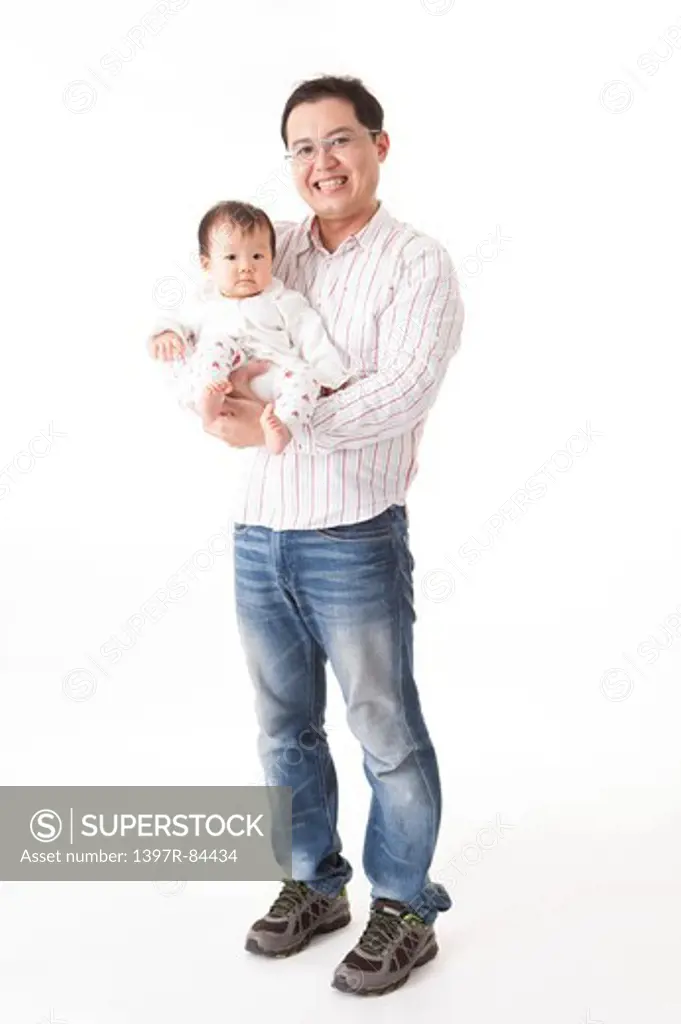Father embracing baby girl with smile