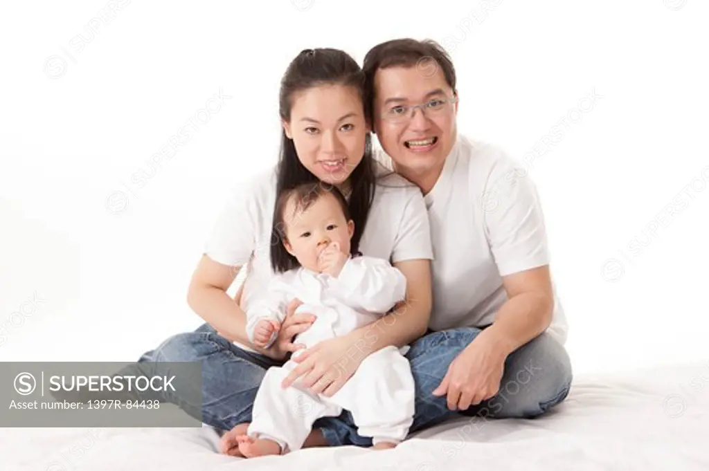Family with one child sitting and smiling at the camera together