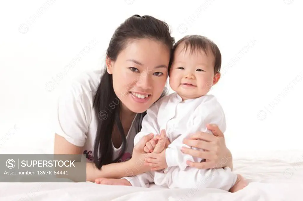 Mother holding baby girl with smile