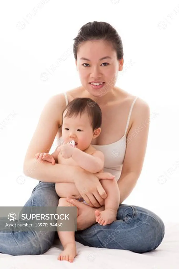 Mother embracing baby girl with smile