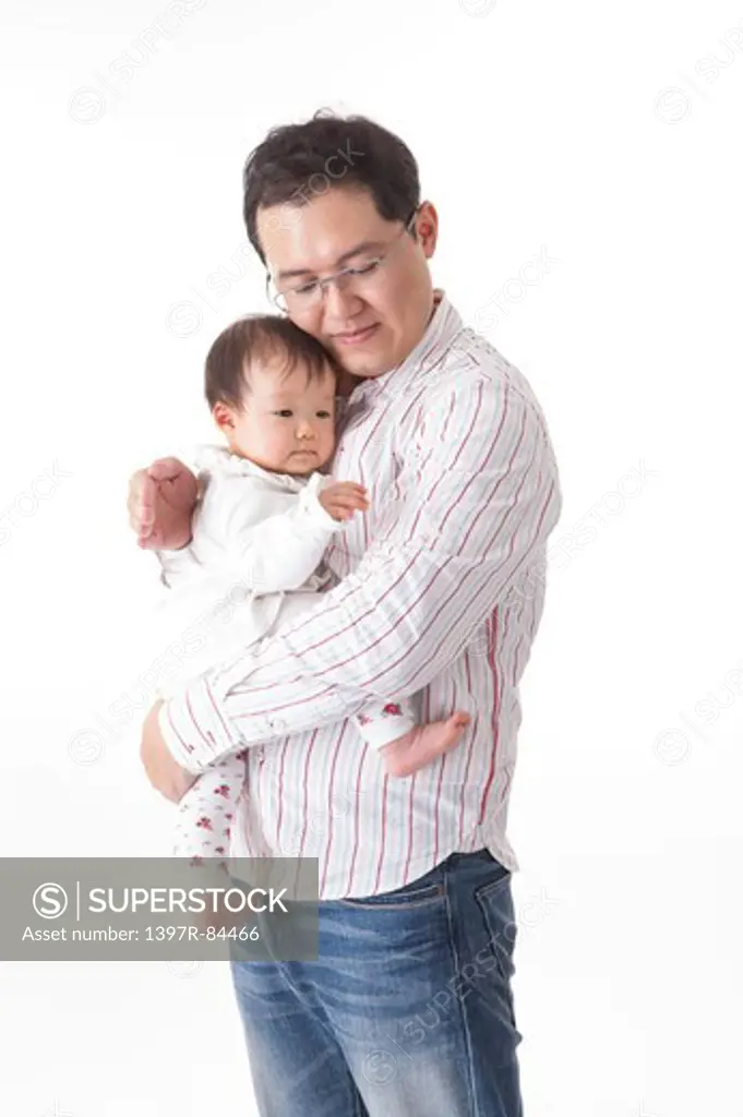 Father holding baby girl and looking down