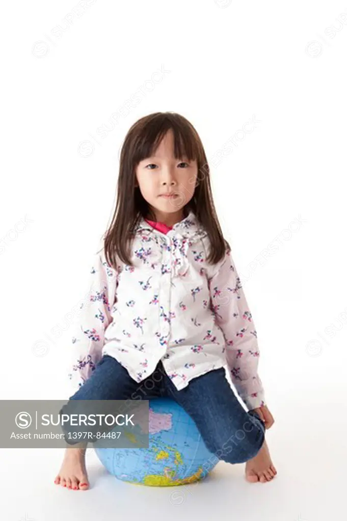 Girl sitting on an inflatable globe