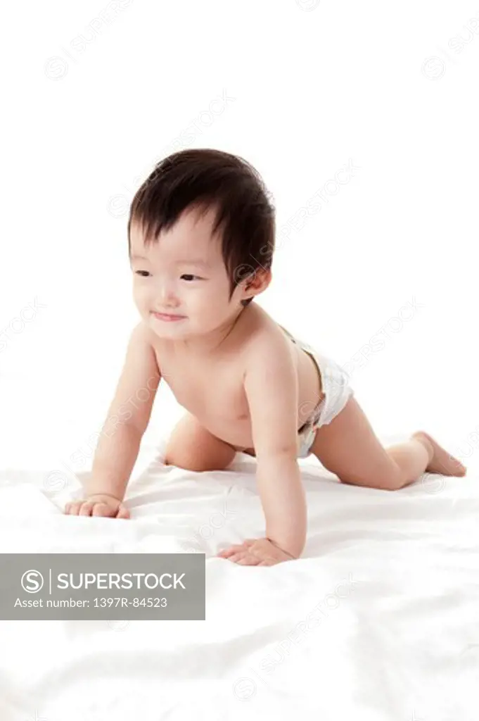 Baby girl crawling on sheet