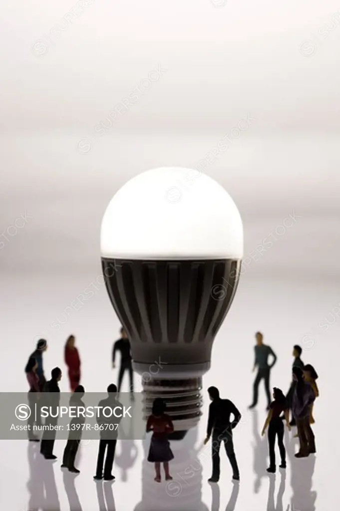 Illuminated light bulb surrounded by figurines