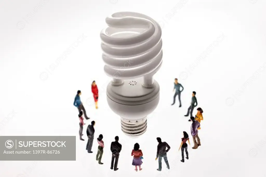 Energy saving light bulb surrounded by figurines