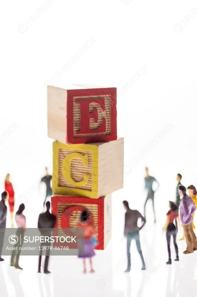 Stacking toy bricks with ECO letters on them, being surrounded by figurines