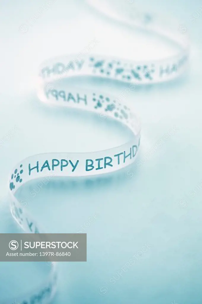 Happy birthday ribbon curling on blue background