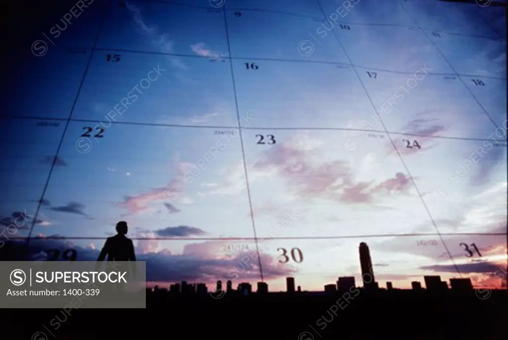 Silhouette of a businessman and buildings superimposed on a calendar