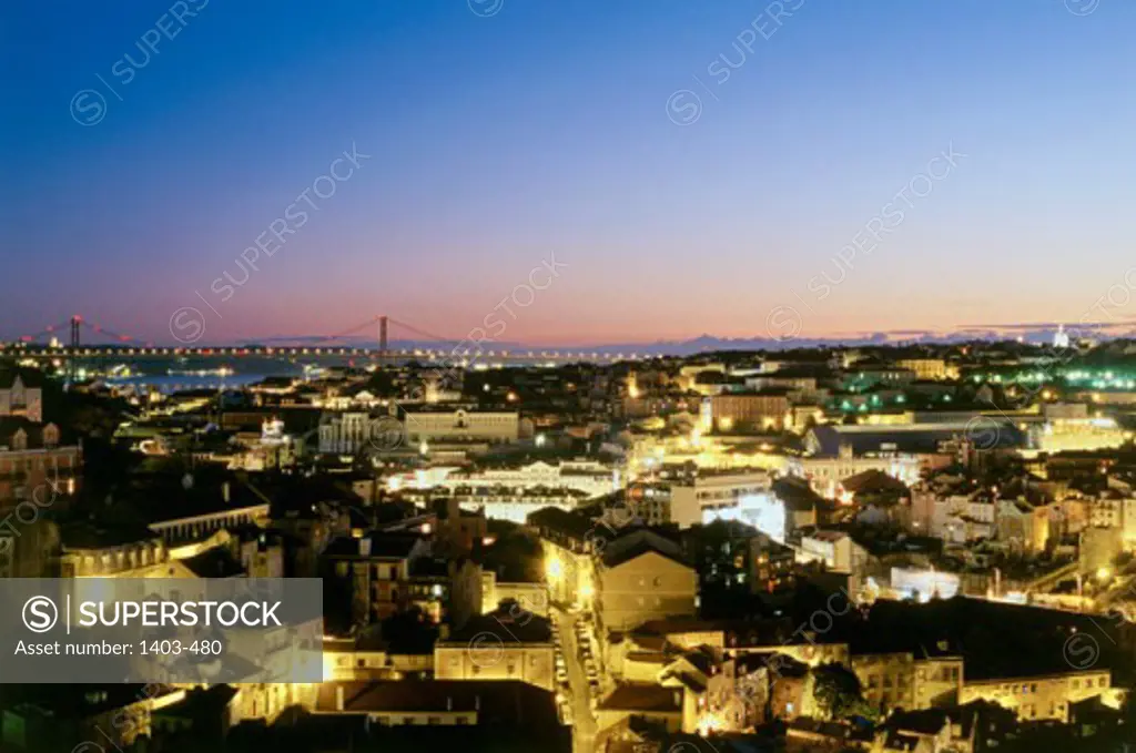 High angle view of buildings in a city lit up at dusk, Lisbon, Portugal
