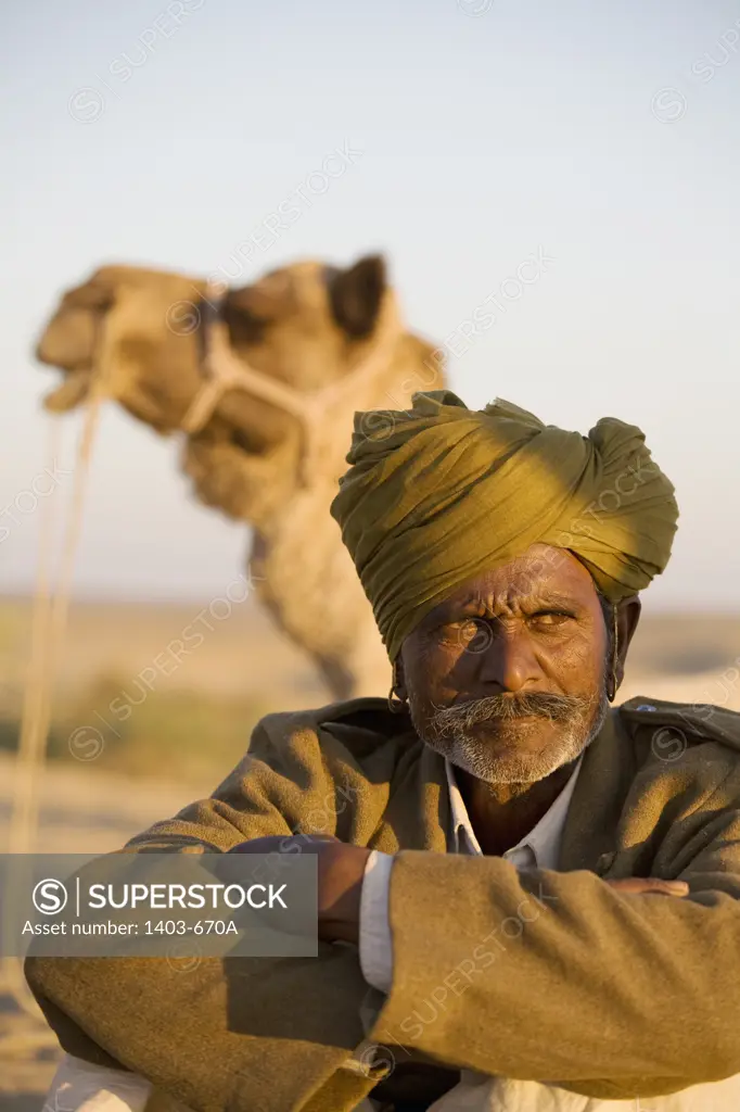 Close-up of a man with a camel in the background, Thar Desert, Khuri, Sikar, Rajasthan, India