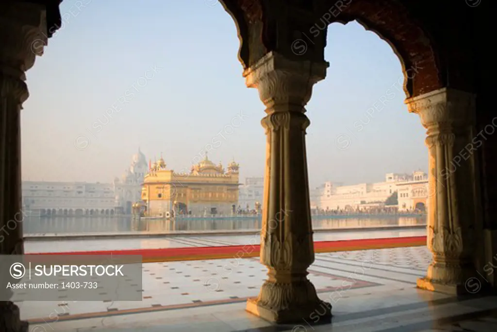India, Amritsar, Golden Temple, View of temple with columns in foreground