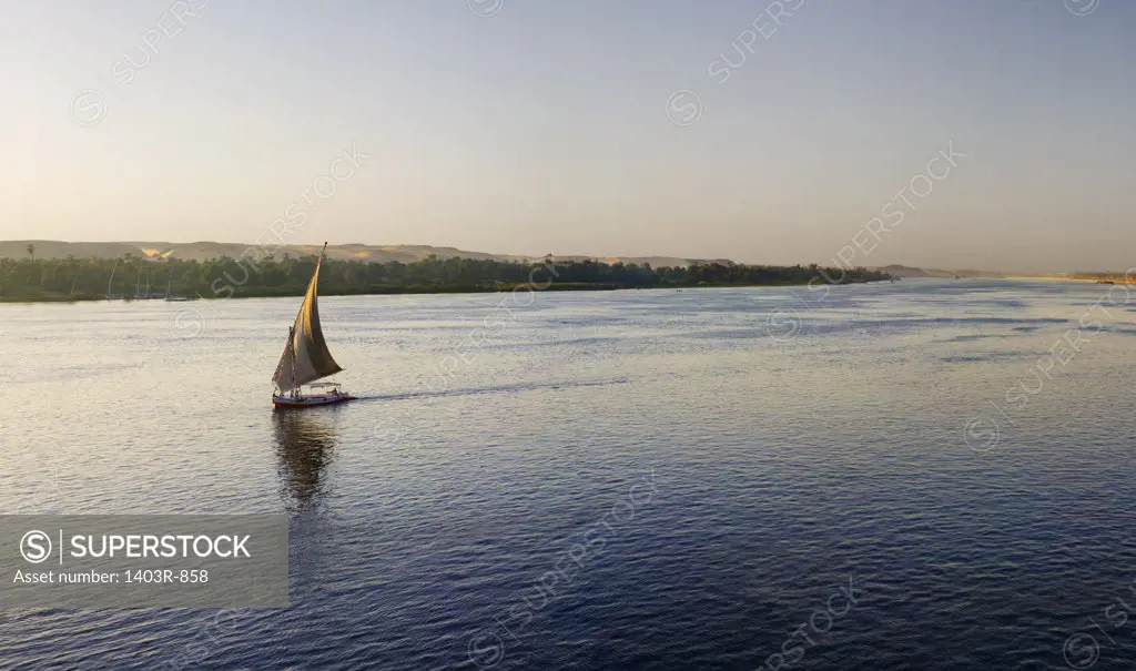 Egypt, Aswan, Panoramic view of felucca sailing down Nile River at sunset