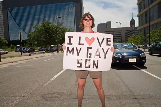 Woman holding a placard in a gay pride parade, Minneapolis, Minnesota, USA
