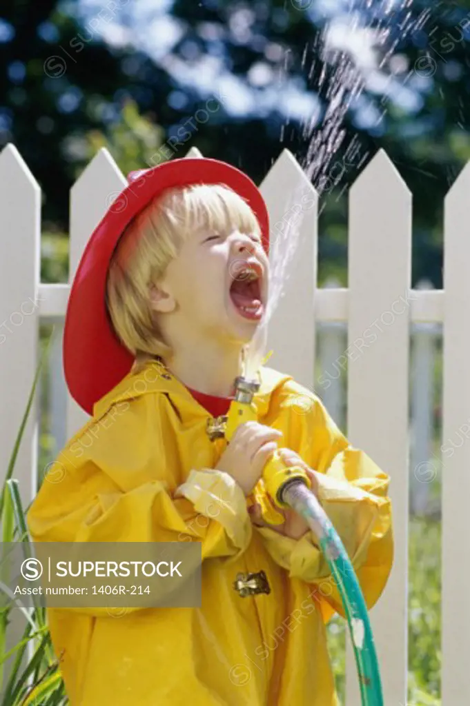 Boy playing with a garden hose