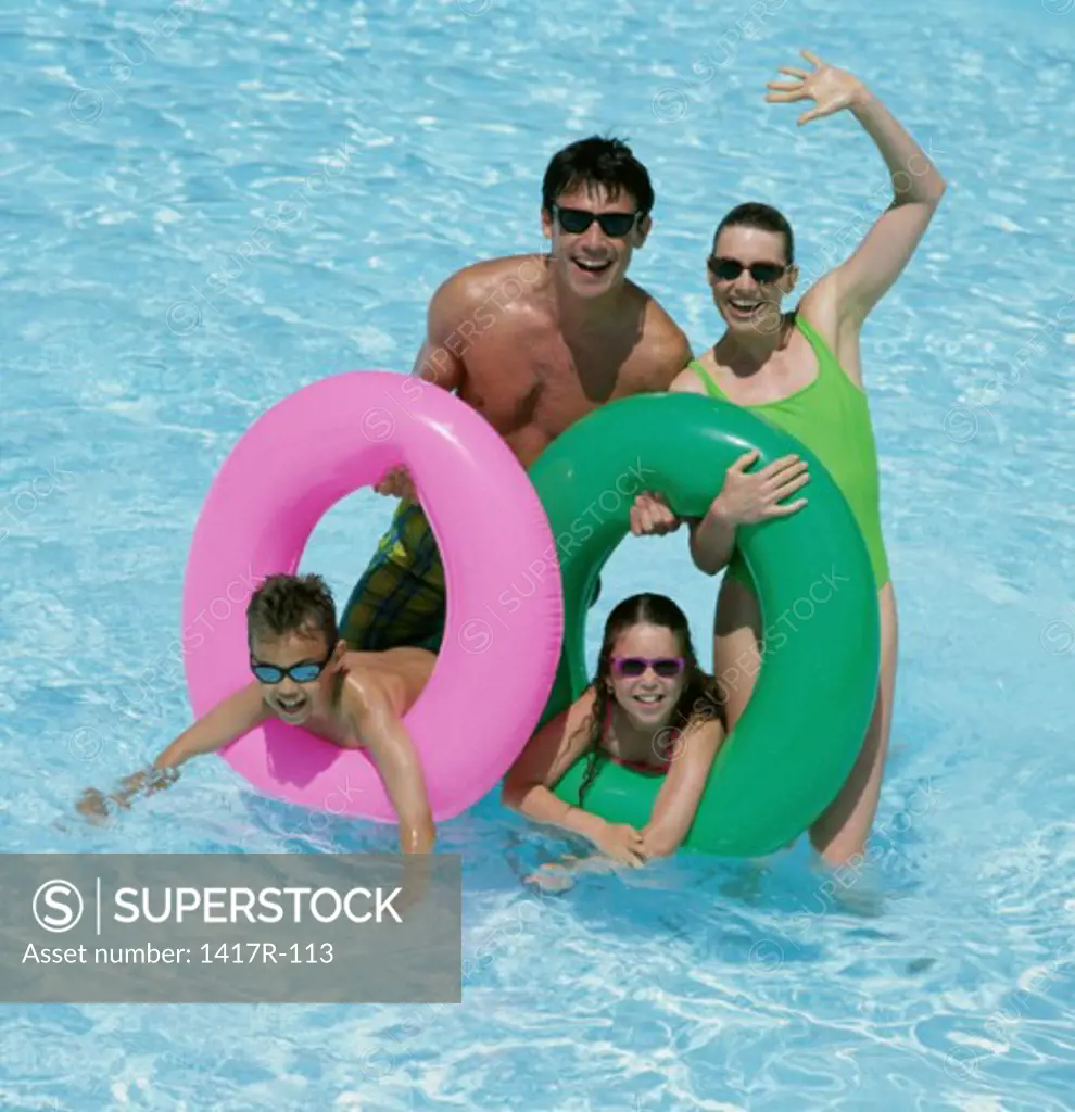 Father and mother with their daughter and son in a swimming pool