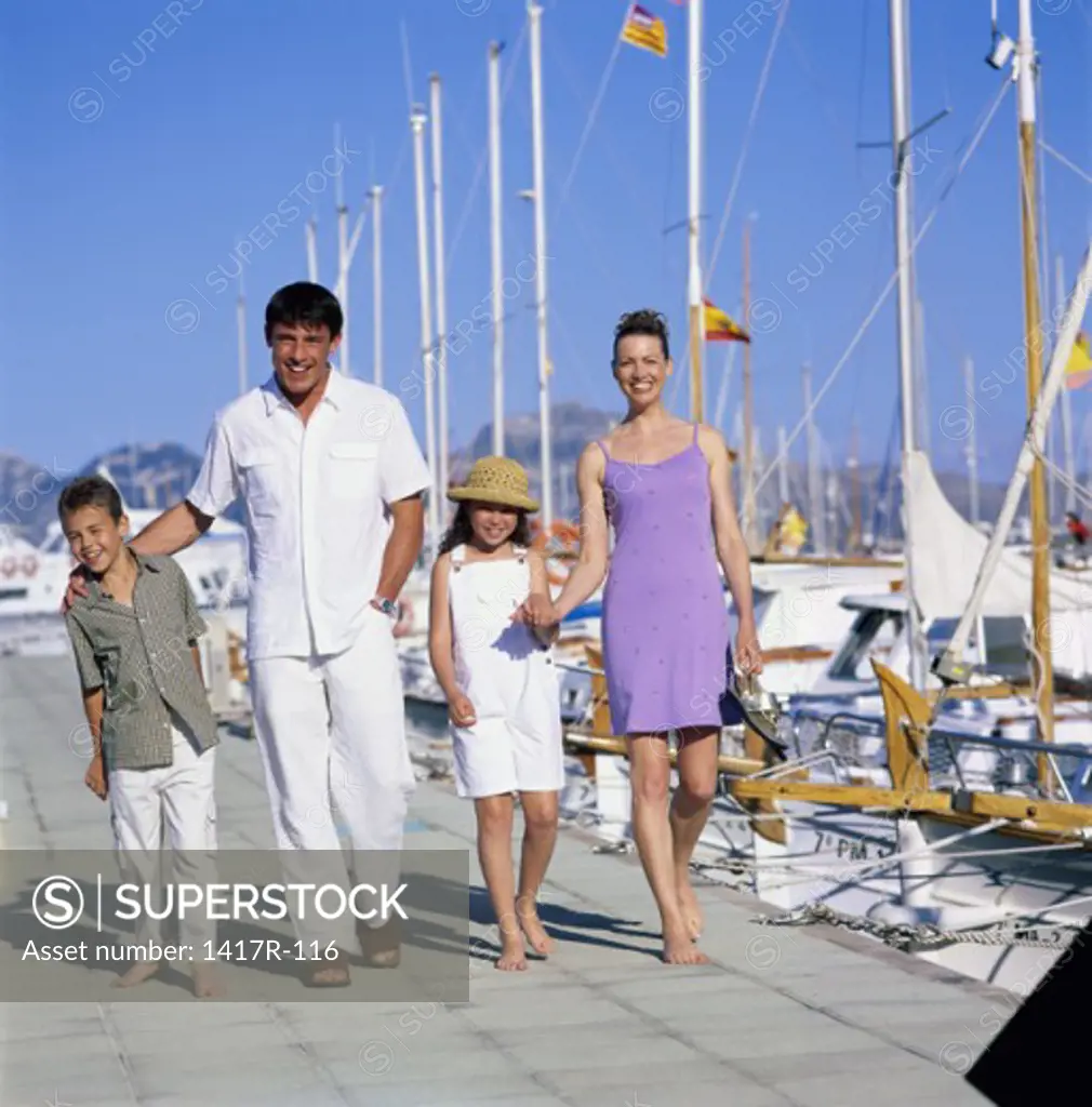 Portrait of parents and their children walking on a pier