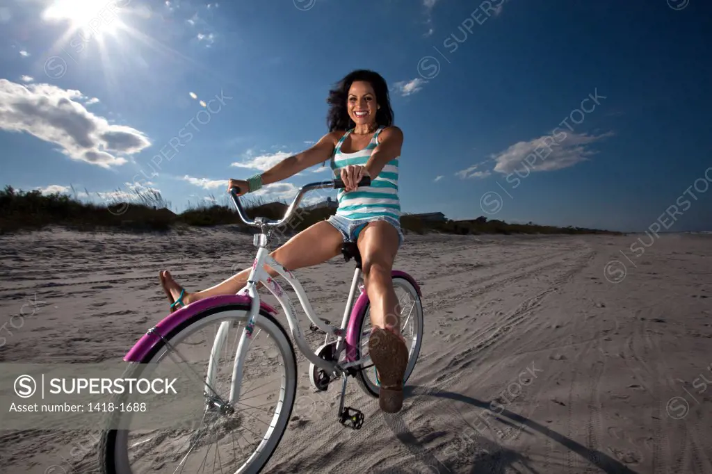 USA, Florida, Woman riding bike on Beach
