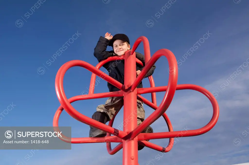 Boy playing on a jungle gym in a park