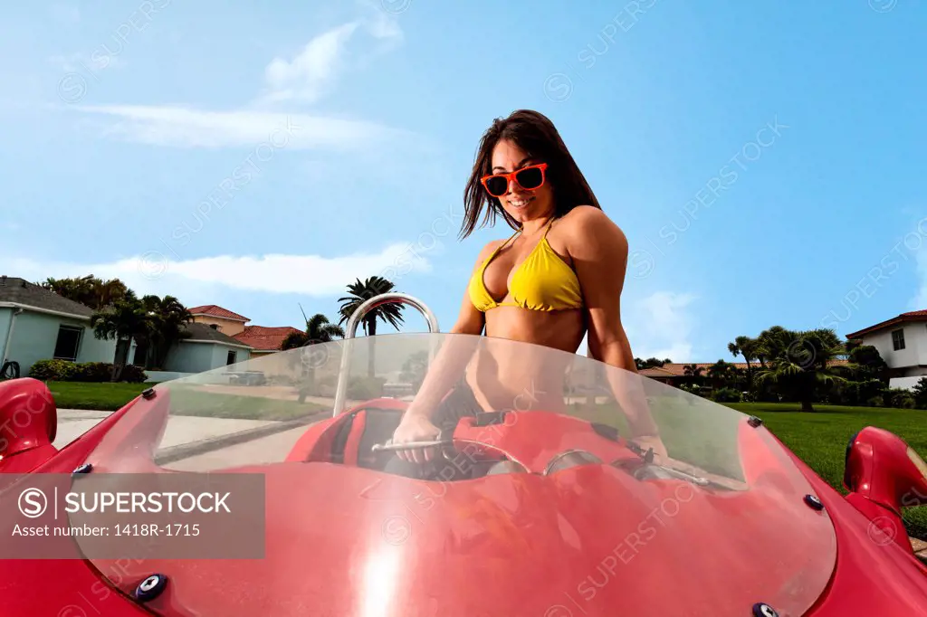 USA, Florida, Orlando, Young woman in bikini riding red motorcycle