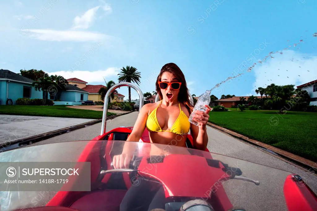 USA, Florida, Orlando, Young woman in bikini riding red motorcycle