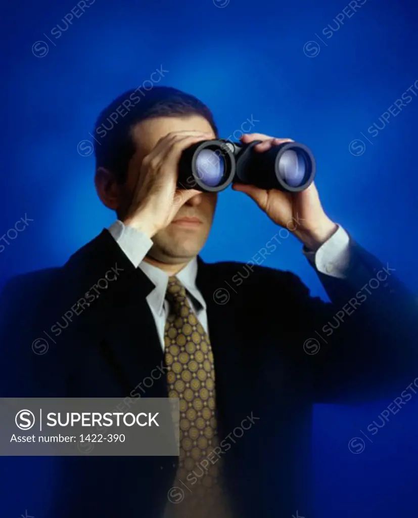 Businessman looking through a pair of binoculars