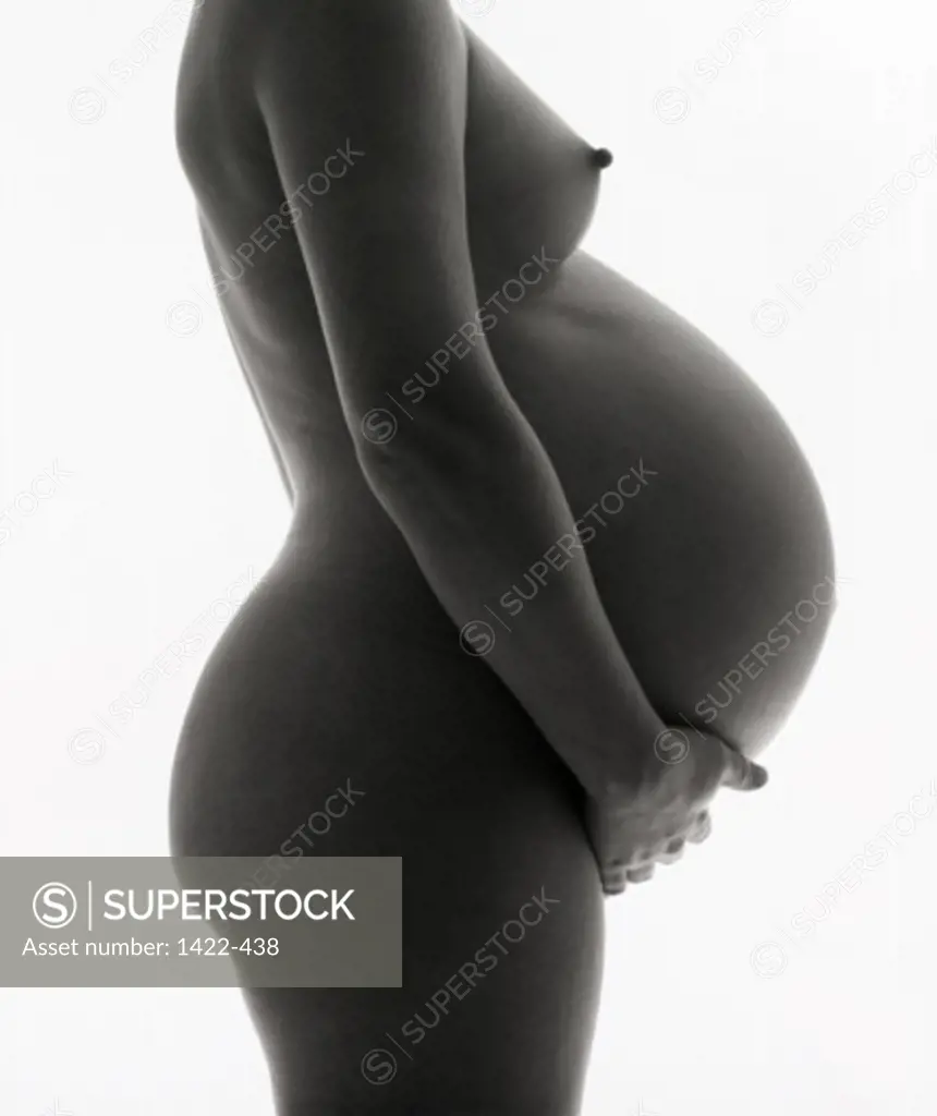 Side profile of the torso of a naked pregnant woman