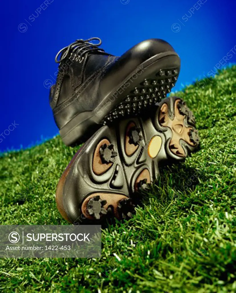 Close-up of a pair of golf shoes on a grassy hill