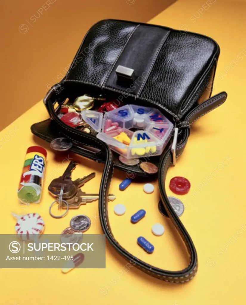 Candies and medicines spilling out from a purse