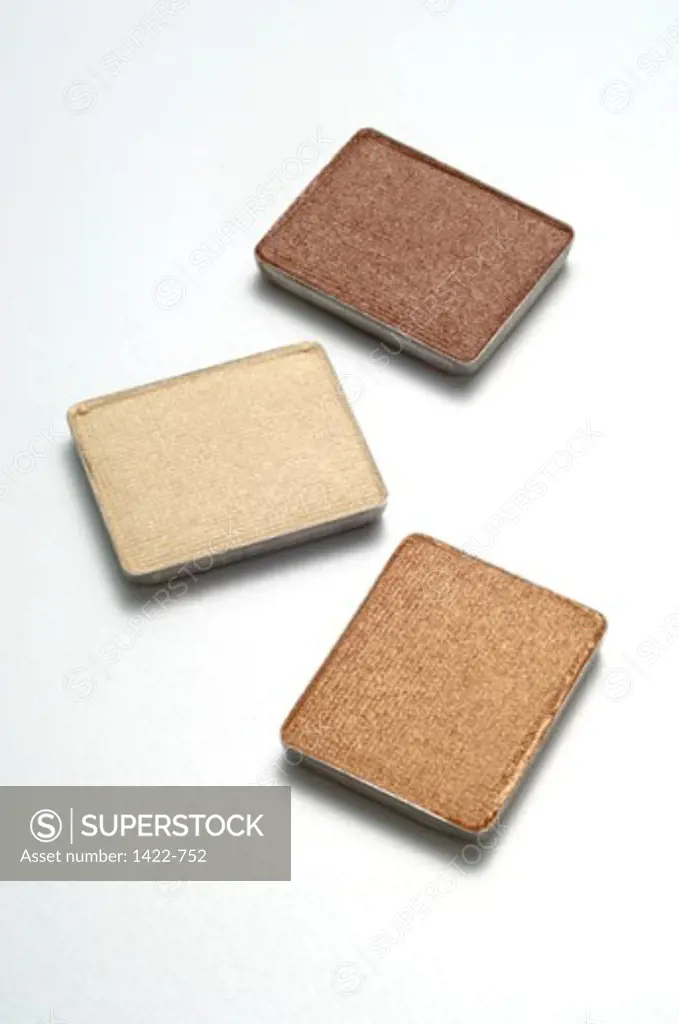 High angle view of three powder compacts
