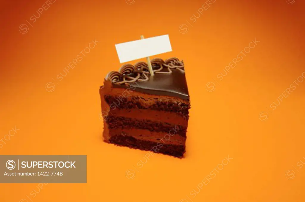 Close-up of a blank nameplate on a slice of a chocolate cake