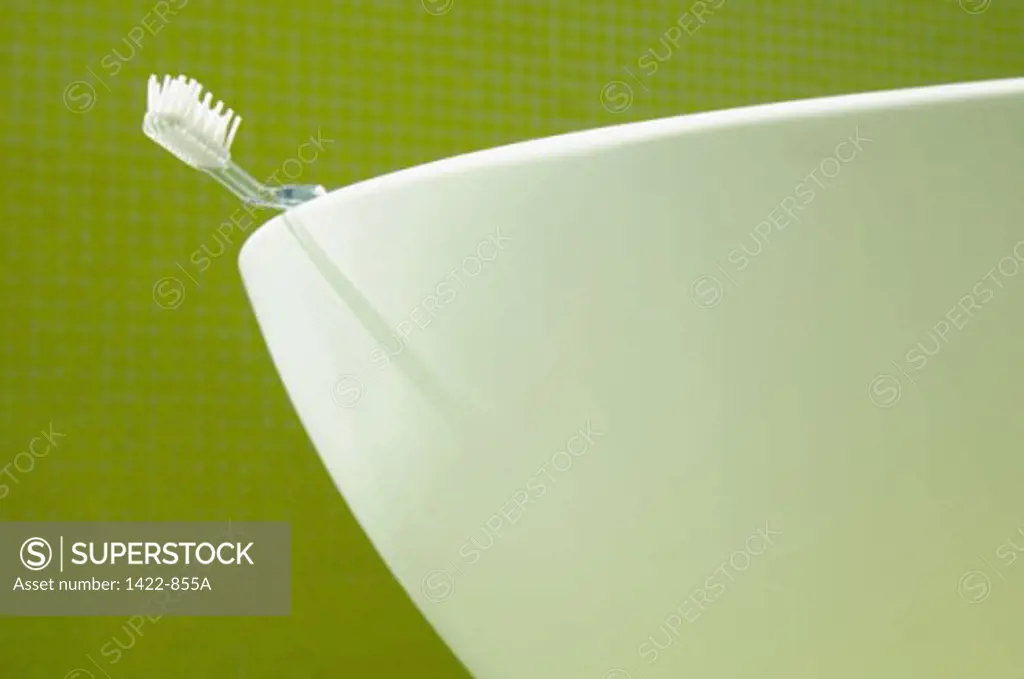 Close-up of a toothbrush on the edge of a bathroom sink