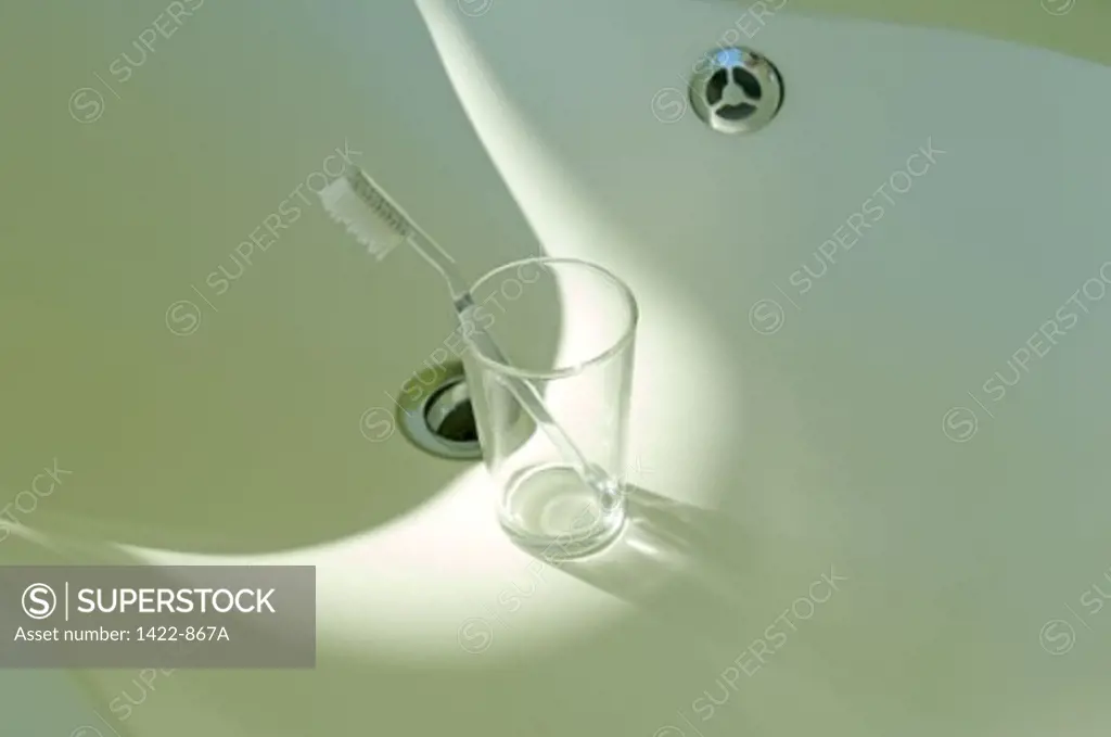 High angle view of a toothbrush in a glass in a bathroom sink