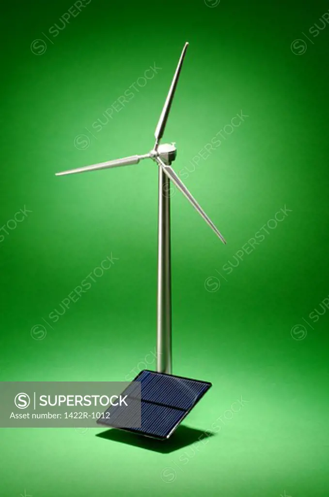 Wind turbine with a small solar panel in a green environment