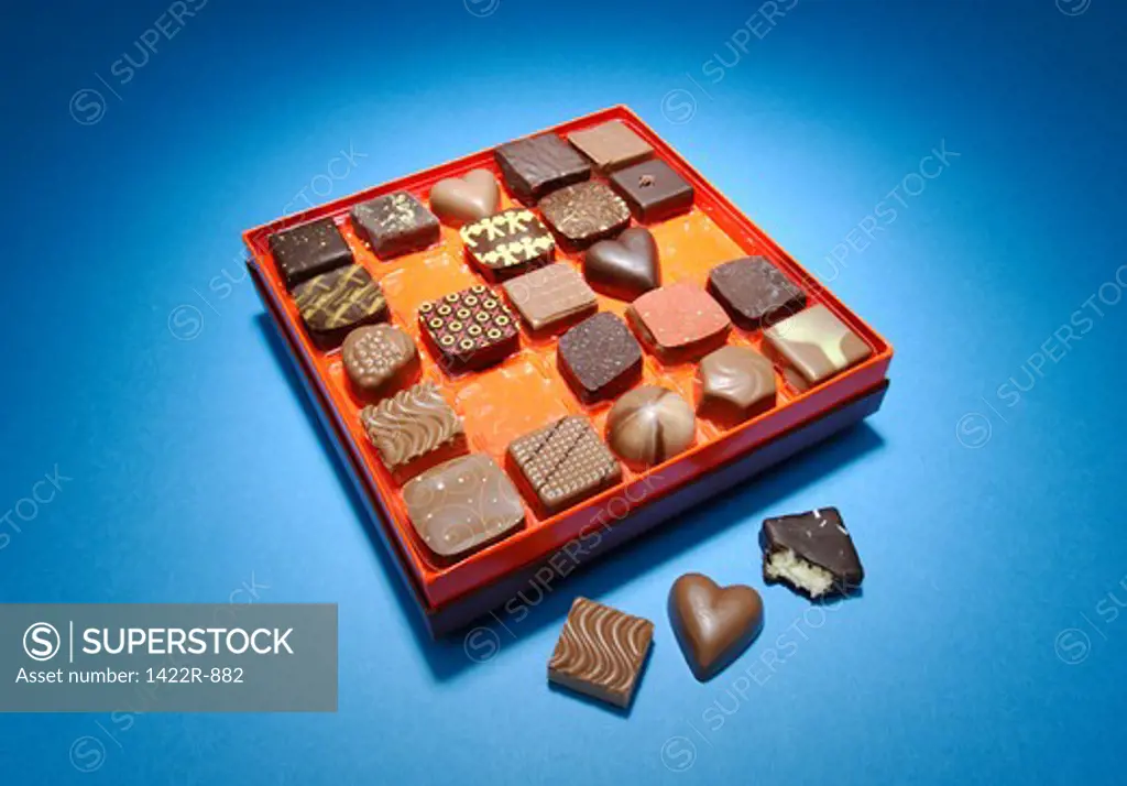 Box of designer chocolate pieces in a box on blue background