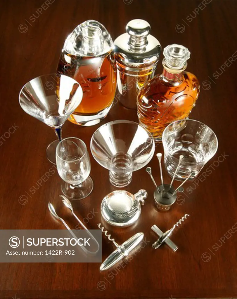 Collection of various drinking supplies, tools and glassware on wooden table