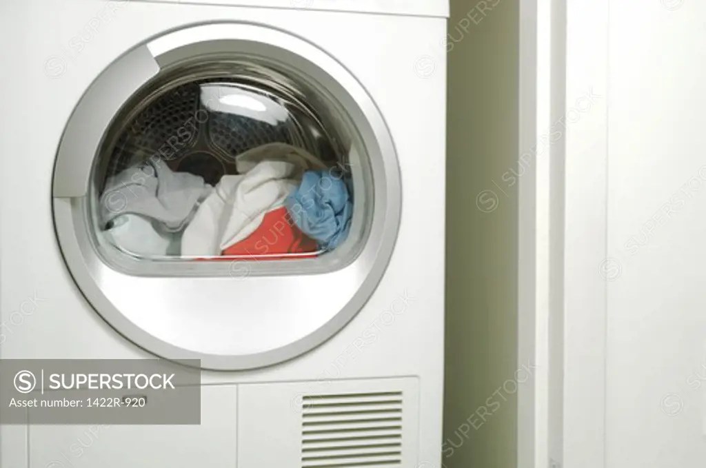 Assorted clothing inside laundry tumble dryer