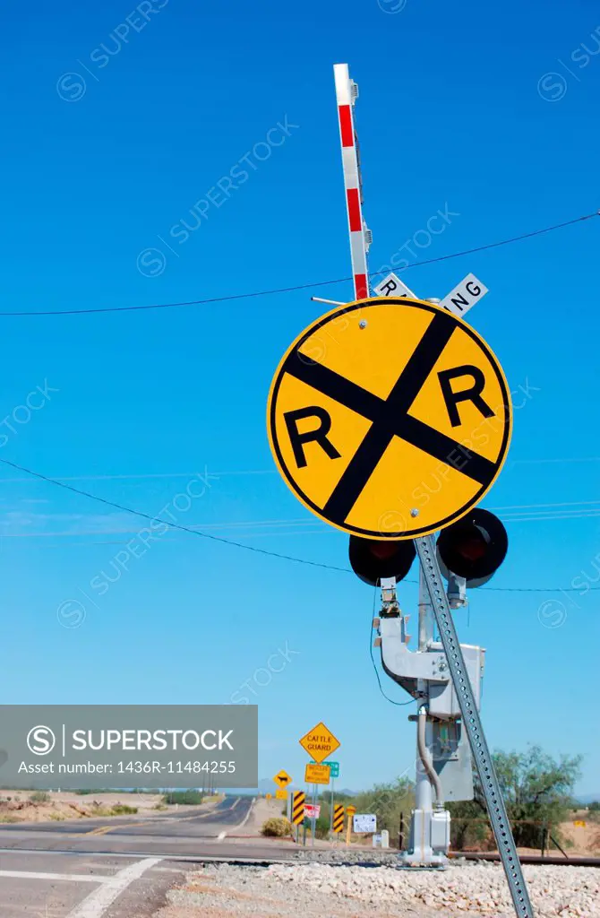 Railroad crossing sign with the gates up.