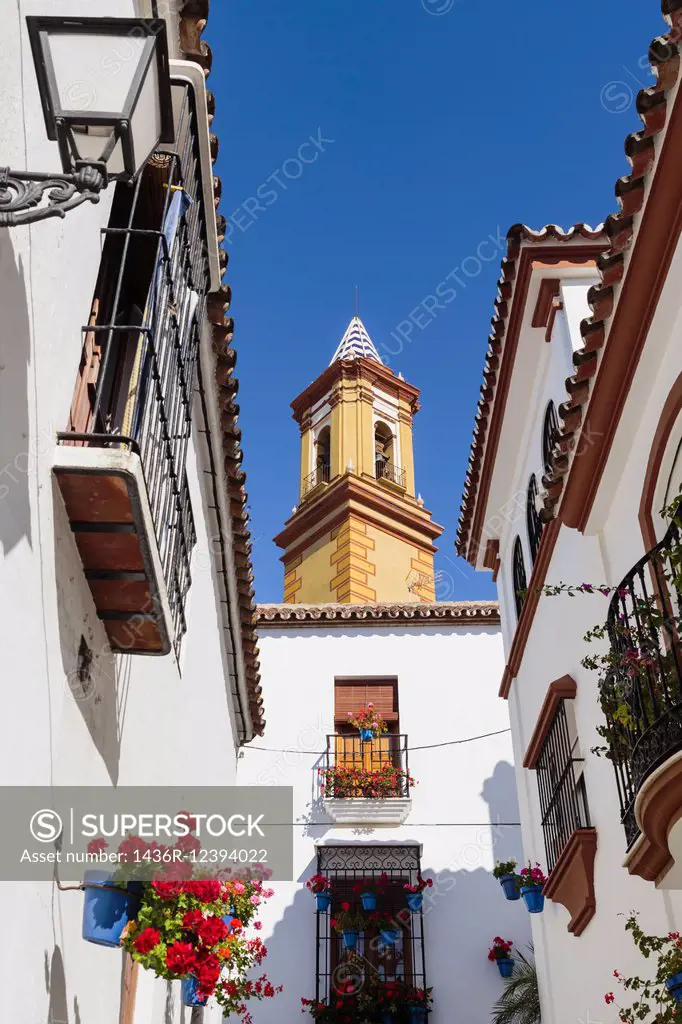 Estepona, Costa del Sol, Malaga Province, Andalusia, southern Spain. Church. Tower of Iglesia de Nuestra Señora de los Remedios church seen at end of ...
