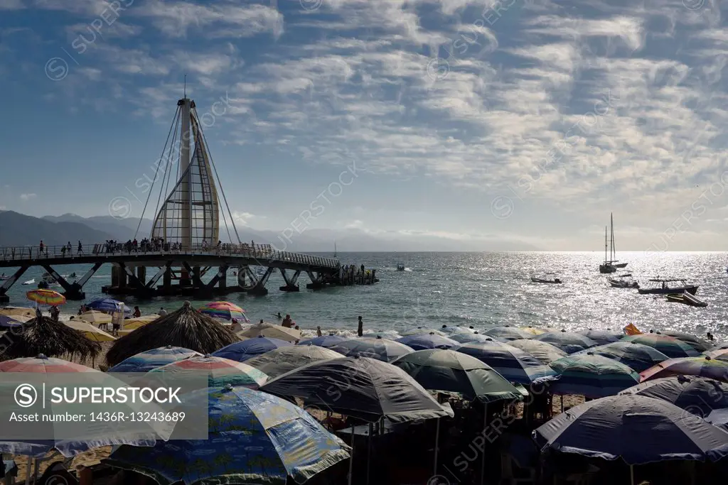 Beach umbrellas on Los Muertos beach at the Pier and Sierra Madre mountains Puerto Vallarta.