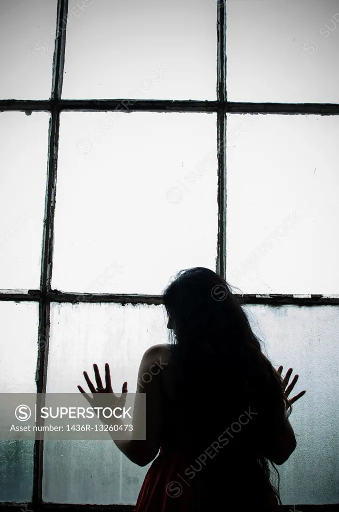 Silhouette of a woman by the window.