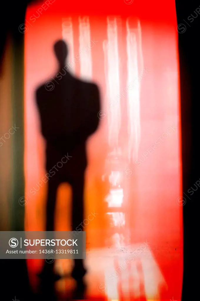 silueta de un hombre irreconocible y de incognito sobre fondo rojo, silhouette of a unrecognizable and incognito man with a red background.