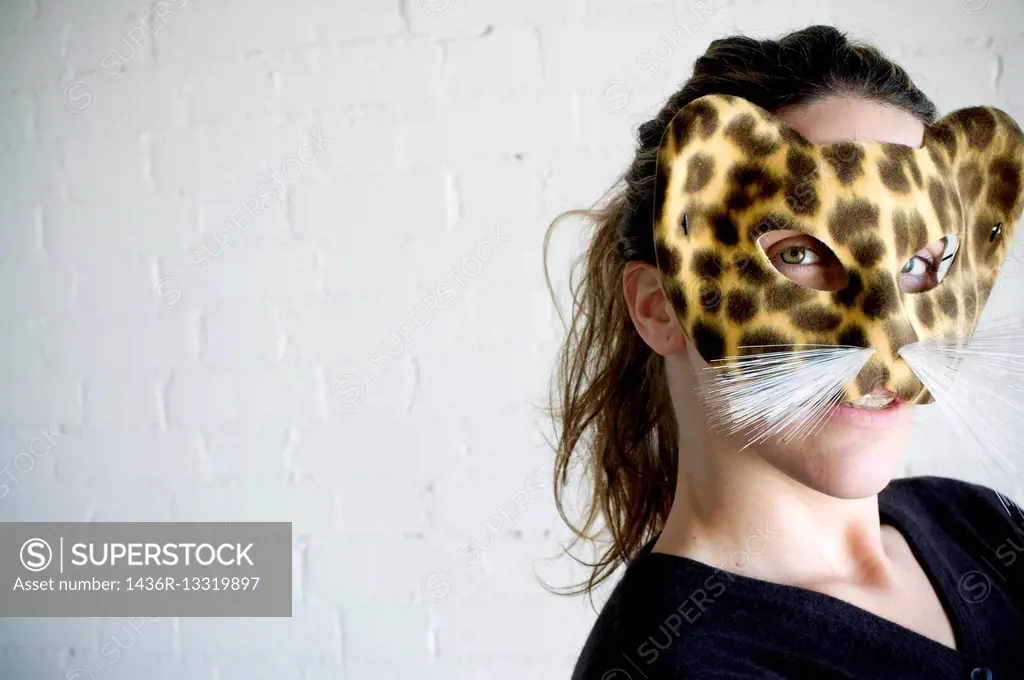 Young woman with a leopard mask and expression of a notty girl