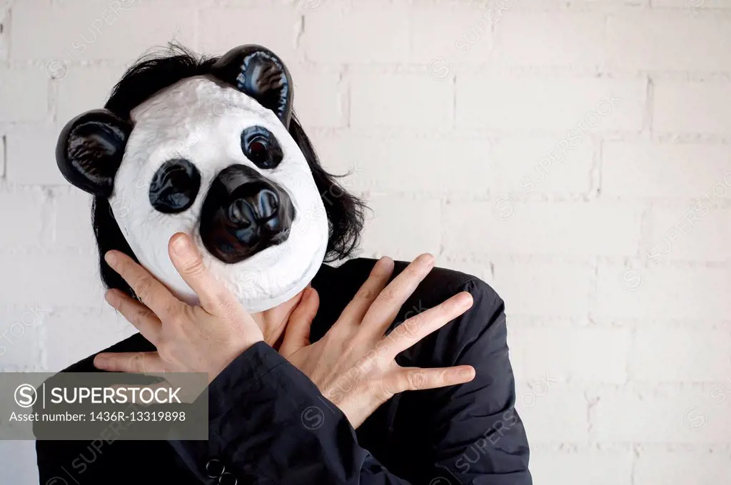Young woman with Panda Bear mask with expression of estress and fear.