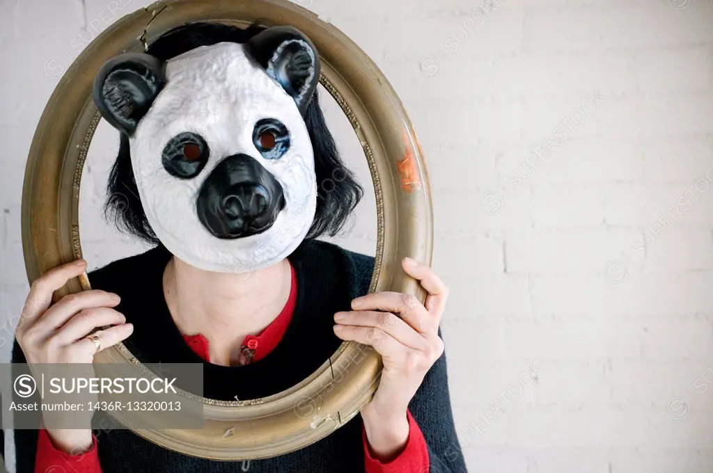 Young woman with an antique frame with Panda Bear mask