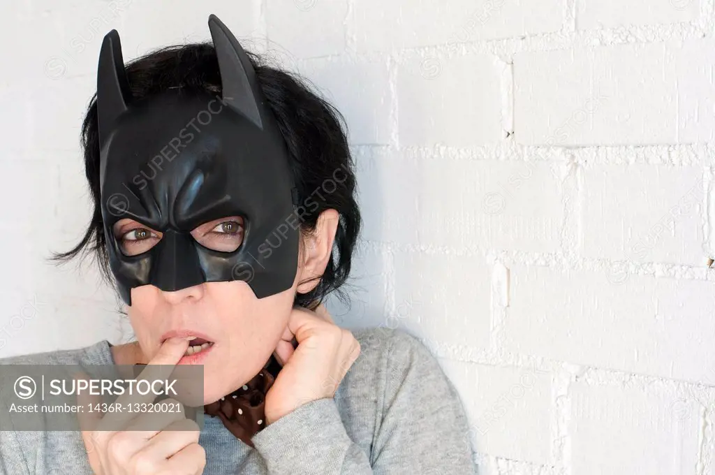 Young woman with a Batman mask and expression of a notty girl