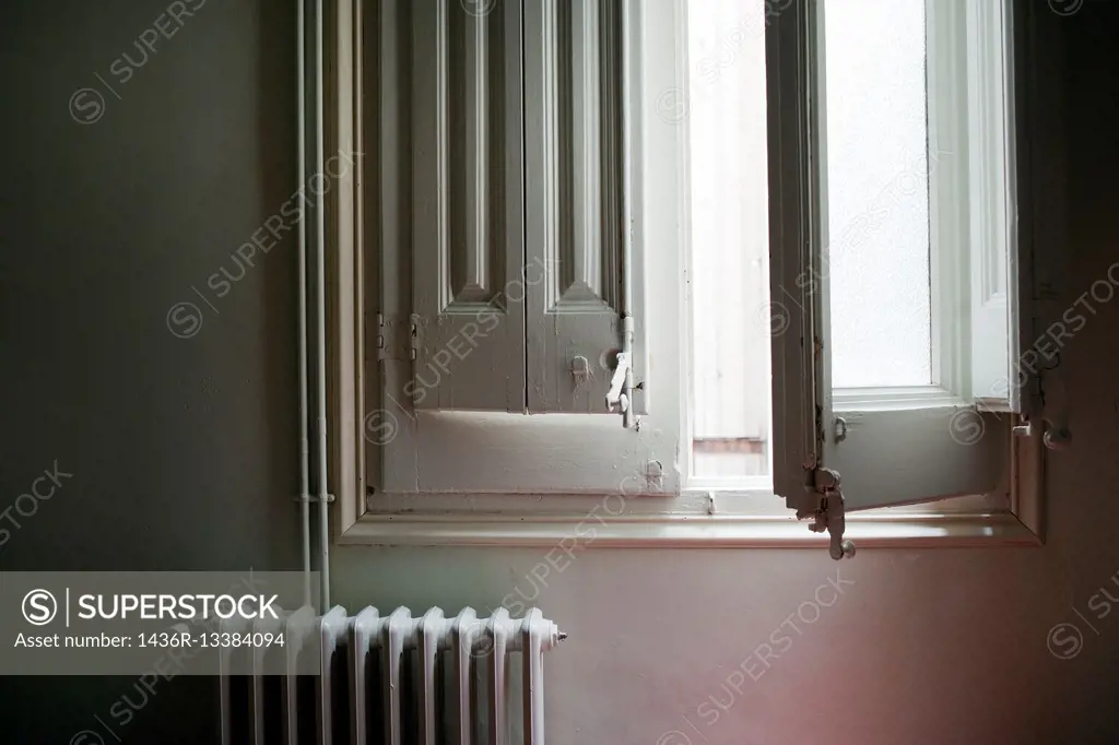 open window in a town house with a central heating radiator.