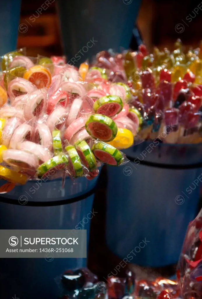 Multi-colored candy lollipops displayed in blue containers. Candy Store