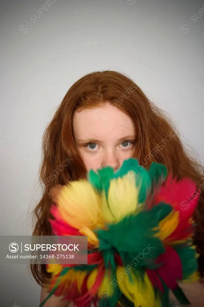 Long red_hair teen girl holding a feather duster