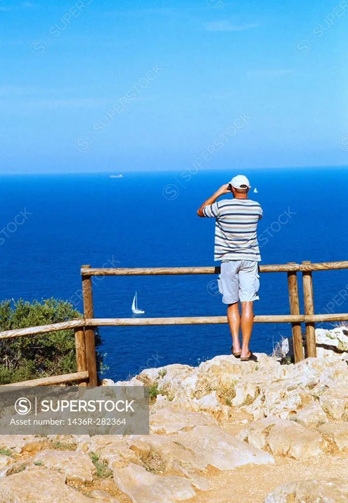 Man with binoculars at viewpoint, Cabo de la Nao. Alicante province, Comunidad Valenciana, Spain